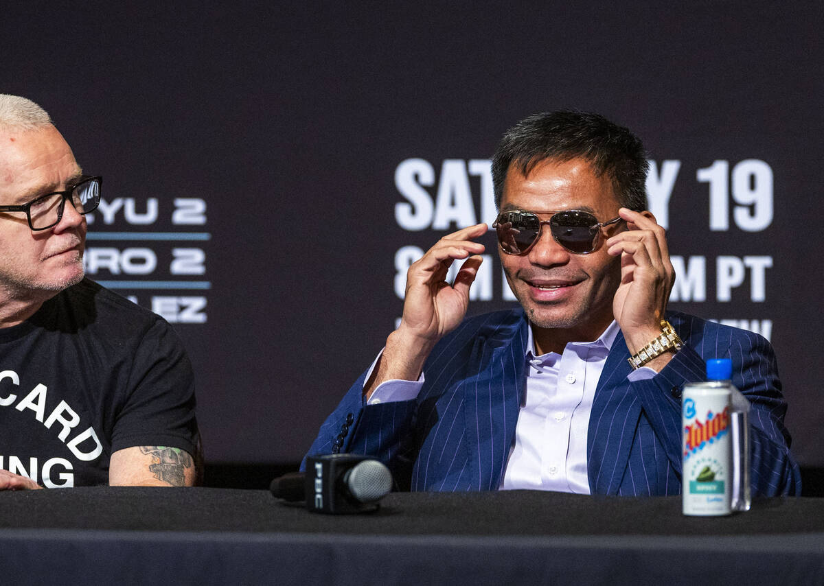 Manny Pacquiao poses for the crowd beside trainer Freddie Roach during a press conference for h ...