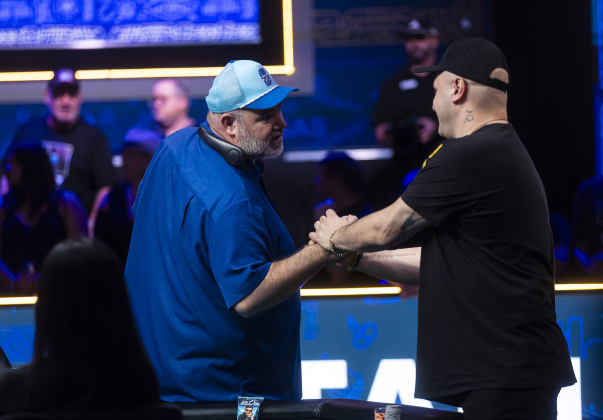 Michael Mizrachi greets John Wasnock as they prepare to continue play for the second day at the ...