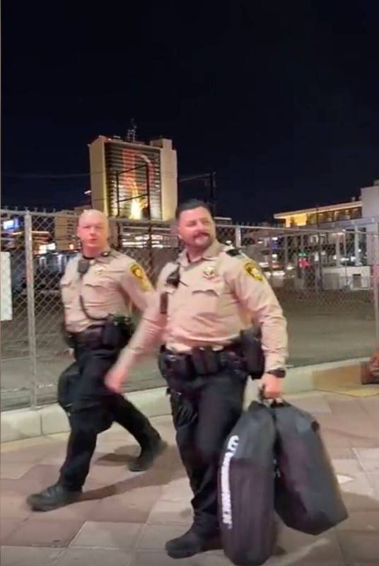 This video screenshot shows Metro officers walking past Karlin Martinez and Cesar Corrales befo ...