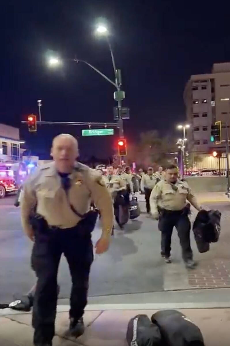 This video screenshot shows Metro officers approaching Karlin Martinez and Cesar Corrales to ma ...