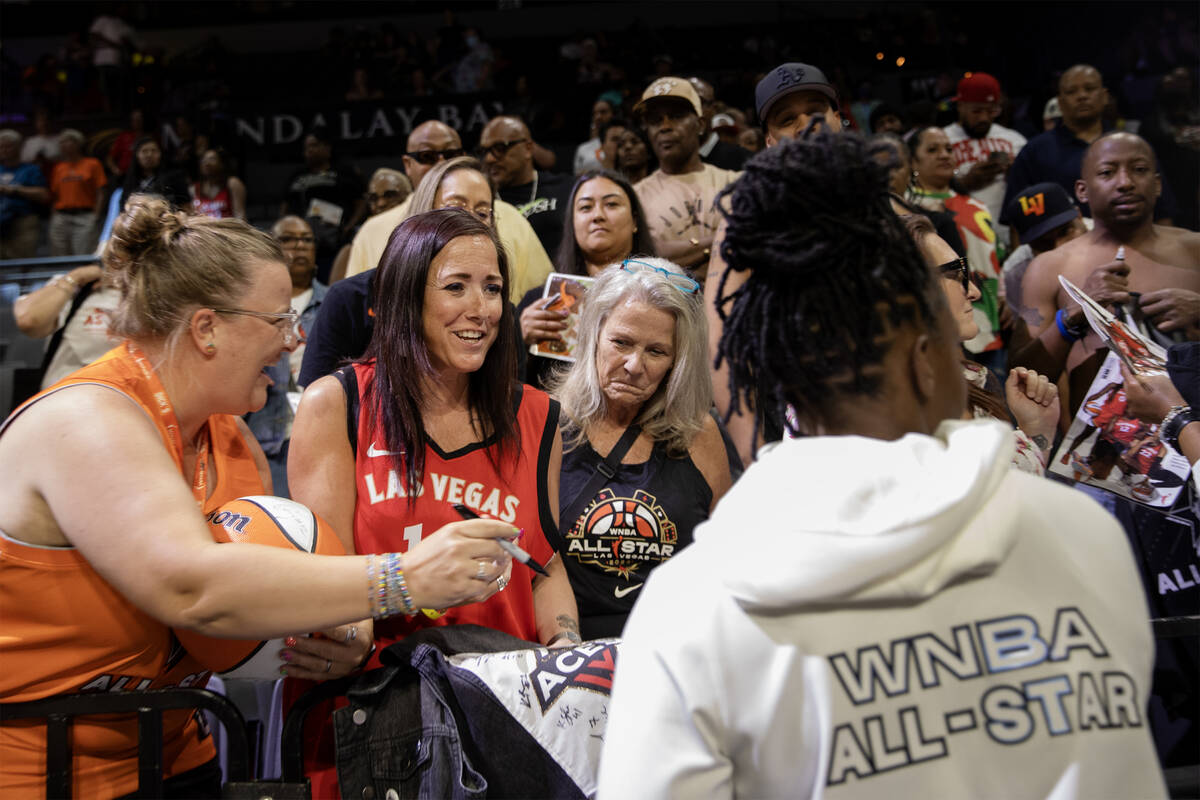 Las Vegas Aces' Chelsea Gray, right, signs autographs for fans after the WNBA All-Star basketba ...