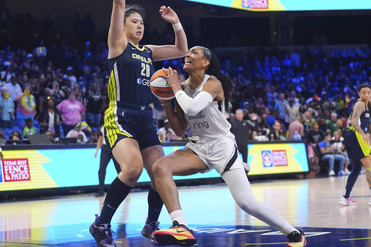 Las Vegas Aces center A'ja Wilson (22) drives against Dallas Wings center Li Yueru (28) during ...