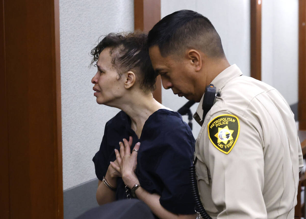 Devyn Michaels, who is accused of killing her boyfriend, is led out of a courtroom after protes ...