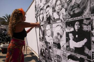 Special needs teacher Deja Nebula sets up an art installation displaying names and faces of peo ...