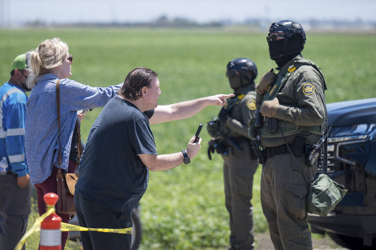 People shout at federal immigration agents during a raid in the agriculture area of Camarillo, ...
