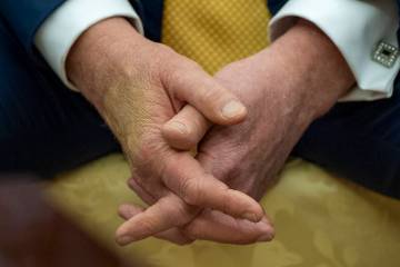 President Donald Trump sits with his hands interlocked as he and Bahrain's Crown Prince Salman ...