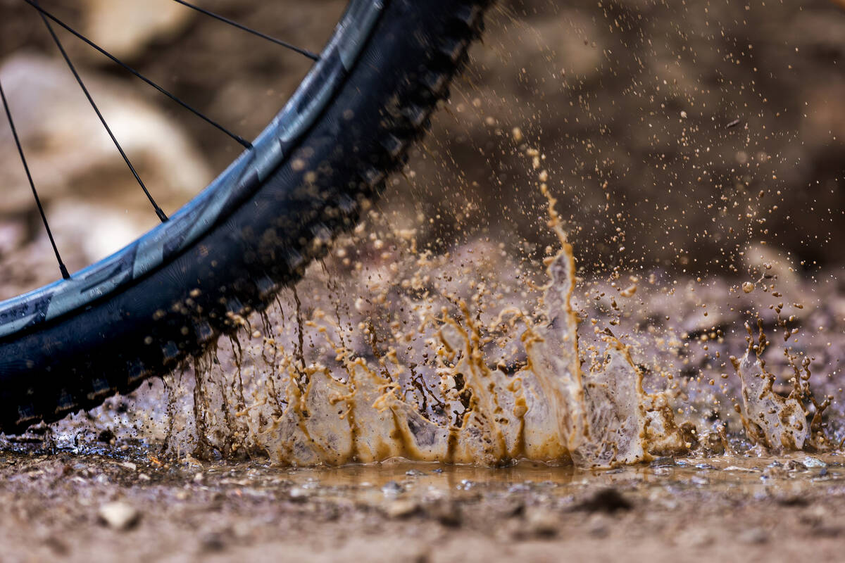 A competitor splashes through a rain puddle during the Viva La Gravity at the Lee Canyon Ski an ...