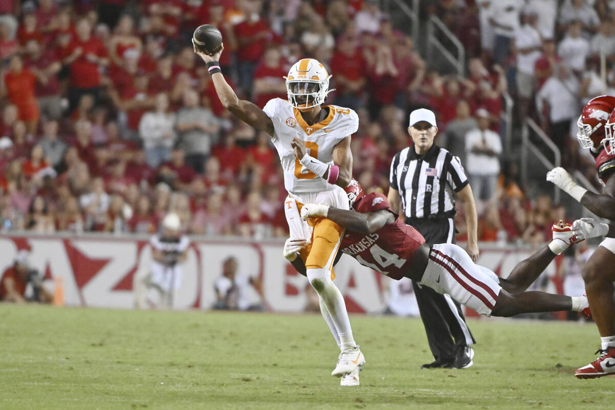 Tennessee quarterback Nico Iamaleava (8) throws under pressure from Arkansas linebacker Stephen ...