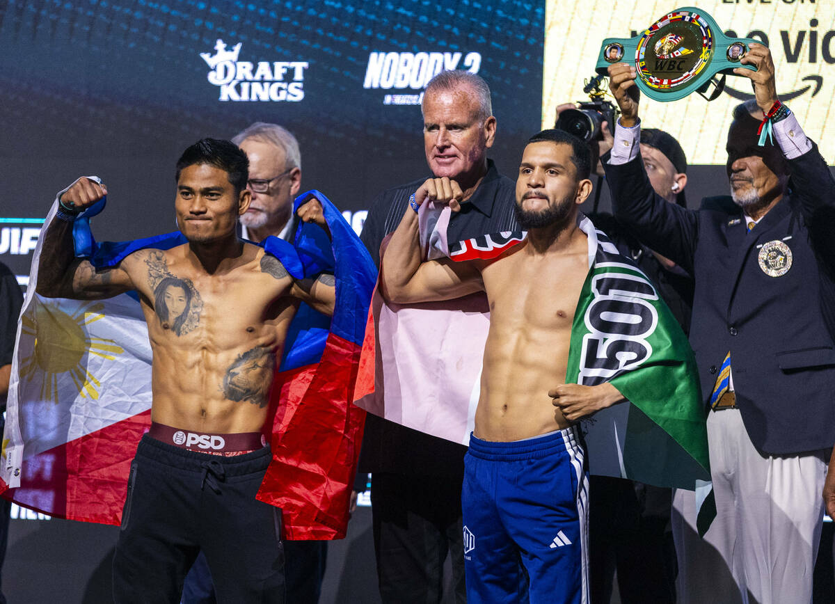 Featherweight fighters Mark Magsayo and Jorge Mata pose off during the ceremonial weigh ins for ...