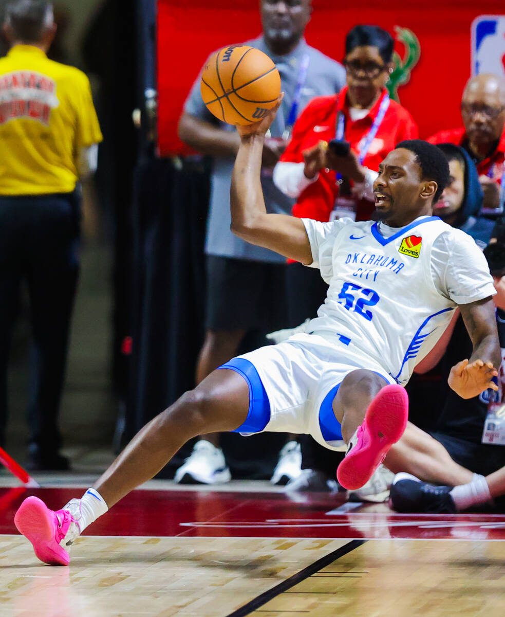 Oklahoma City Thunder forward Zack Austin falls as he passes the ball during an NBA Summer Leag ...