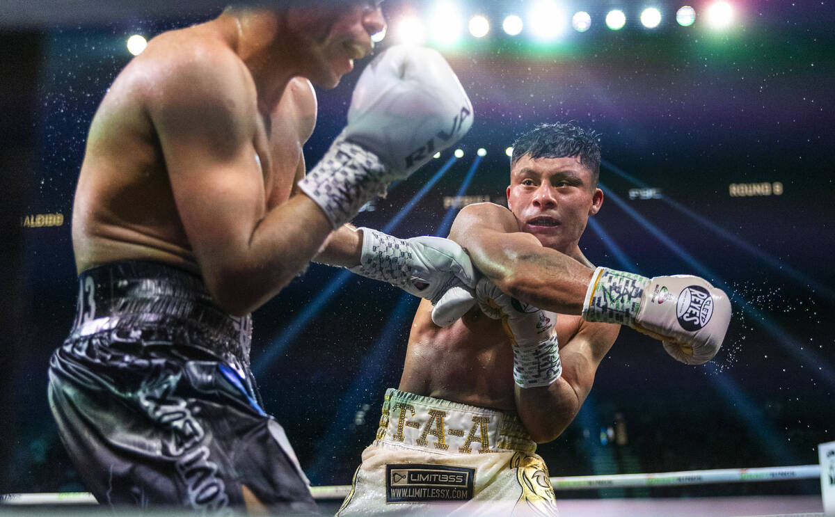 Omar Salcido takes a punch from Isaac Cruz and during their interim WBC super lightweight title ...