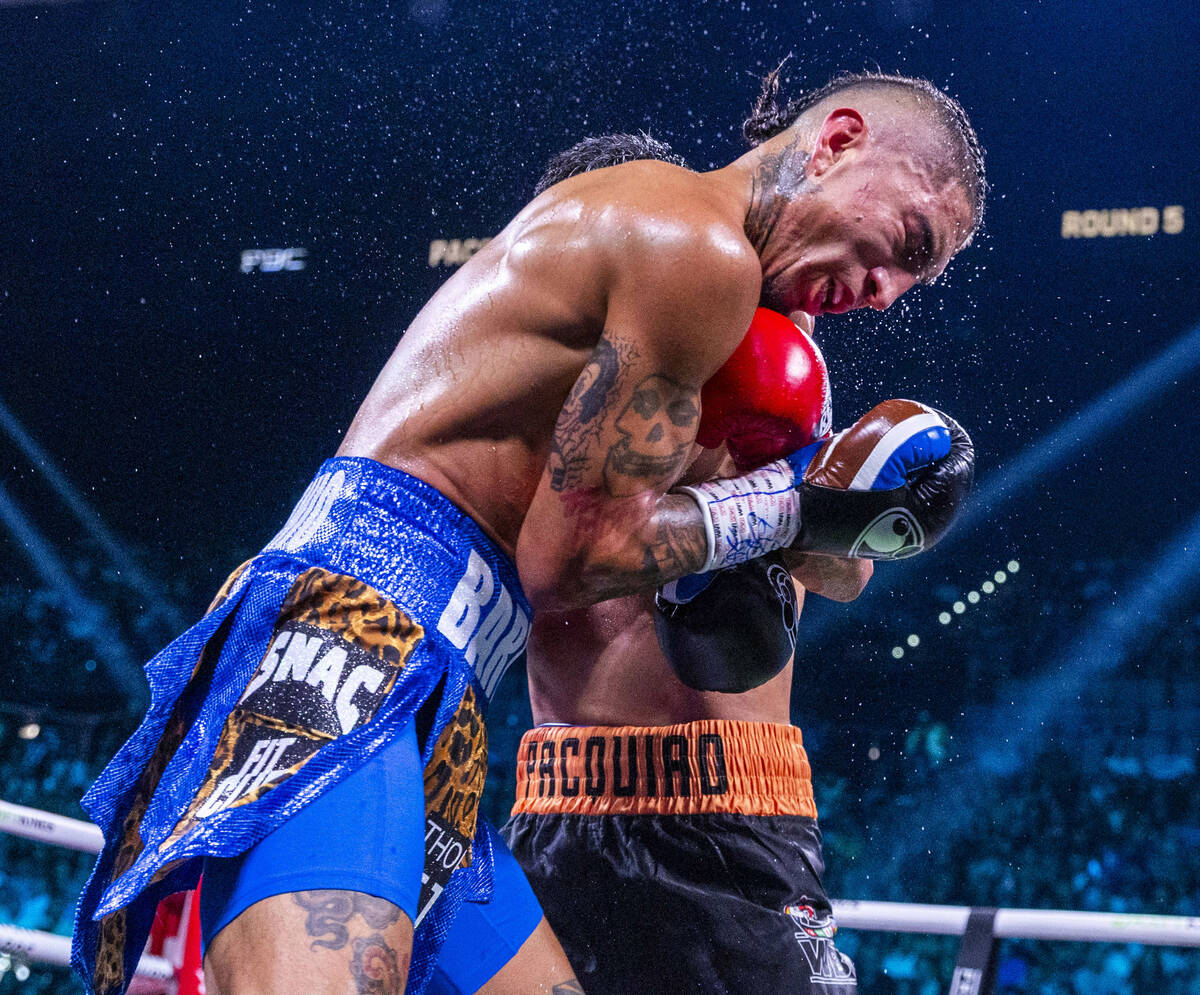 Mario Barrios absorbs an uppercut from Manny Pacquiao during their WBC welterweight championshi ...