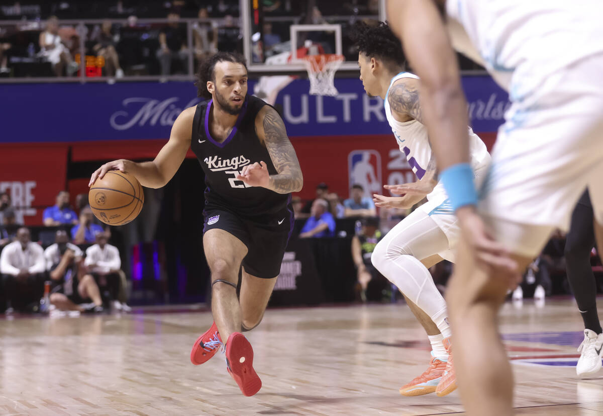 Sacramento Kings guard Devin Carter (22) drives the ball under pressure from Charlotte Hornets ...