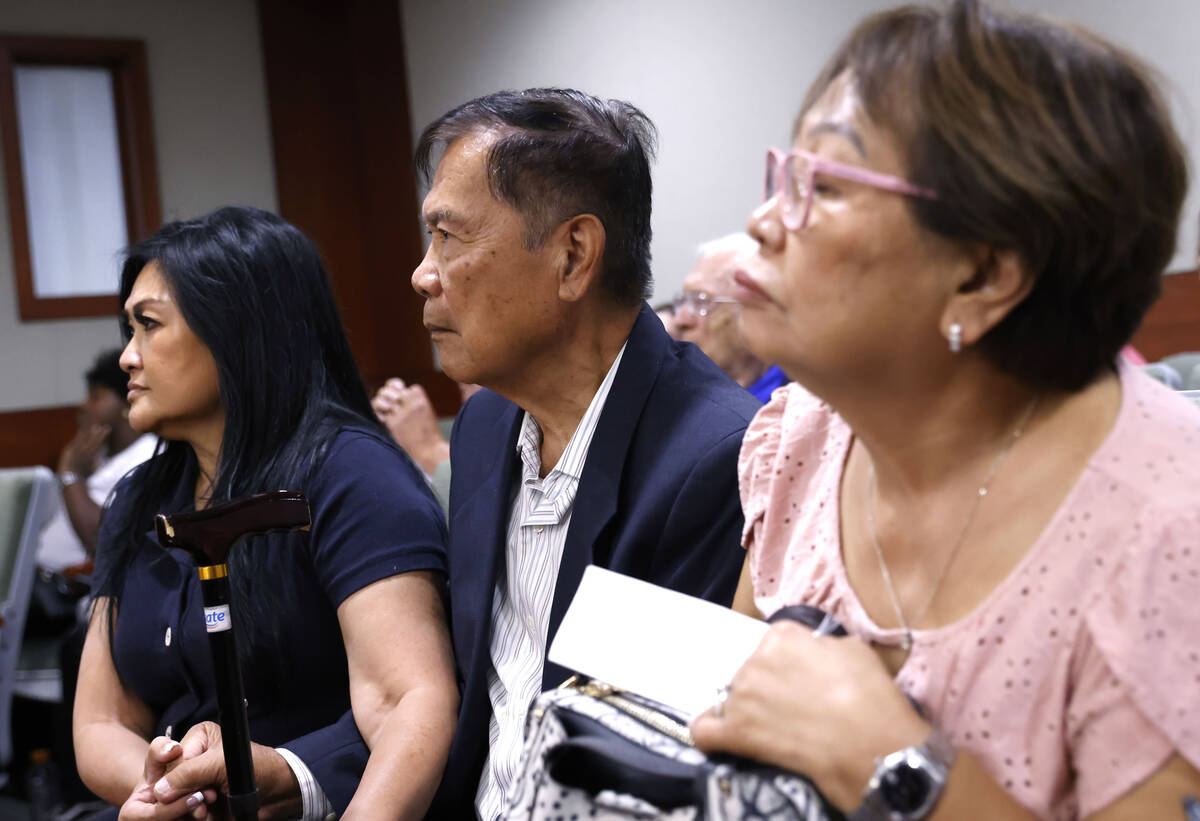 Amadeo Quindara, center, who was the victim of a hate crime attack in his garage, attends with ...