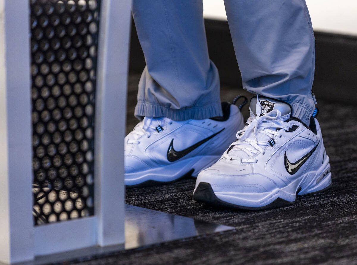 Raiders head coach Pete Carroll wears Nike's with the team logo as he speaks during a press con ...