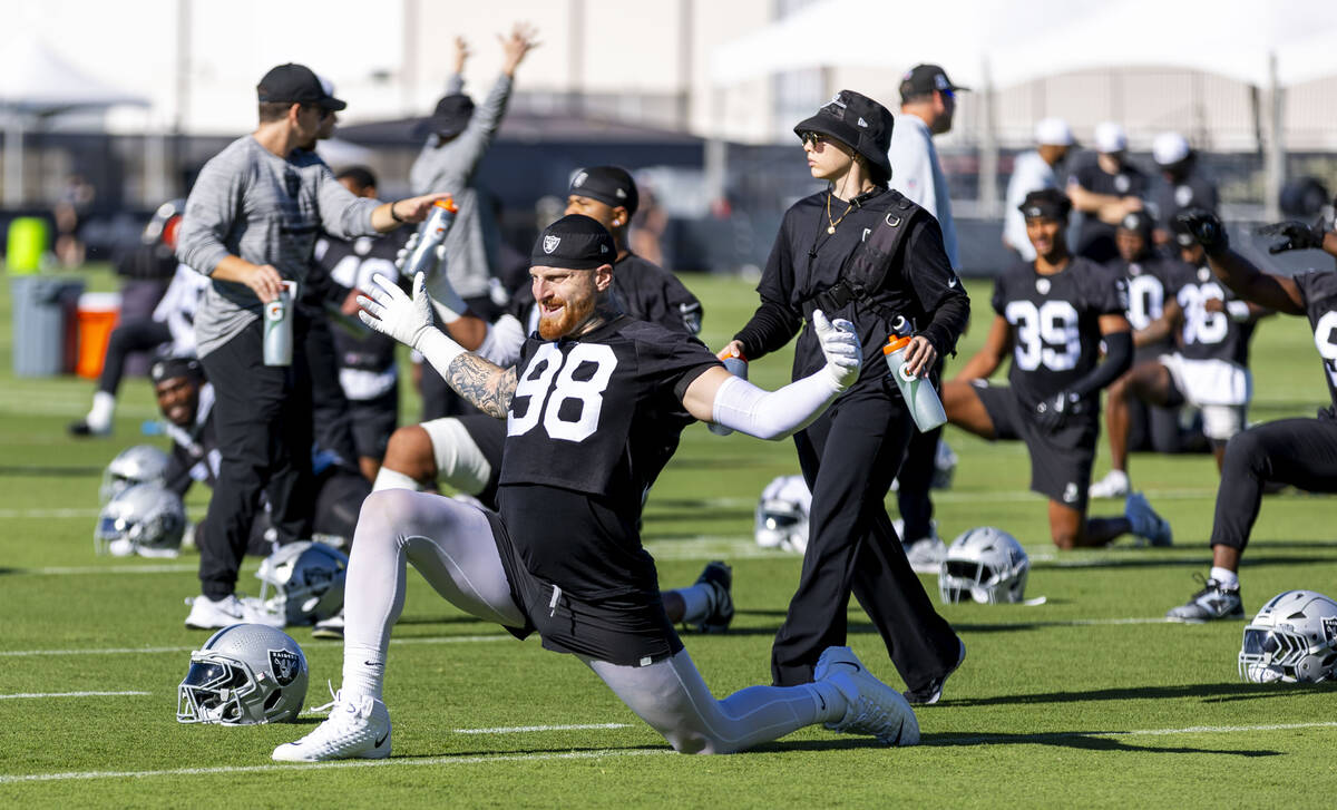 Raiders defensive end Maxx Crosby (98) stretches with teammates during the first day of trainin ...