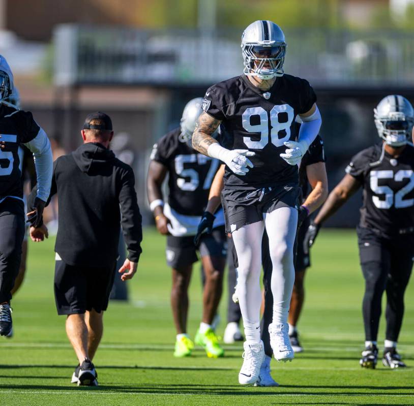 Raiders defensive end Maxx Crosby (98) warms up with teammates during the first day of training ...