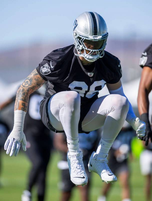 Raiders defensive end Maxx Crosby (98) warms up with teammates during the first day of training ...