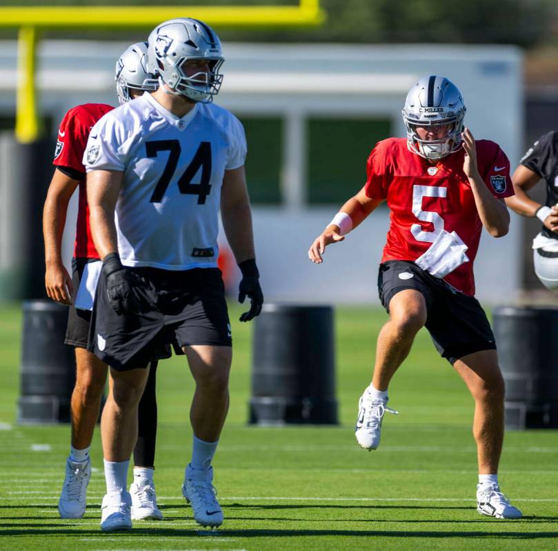 Raiders quarterback Cam Miller (5) warms up with teammates during the first day of training cam ...