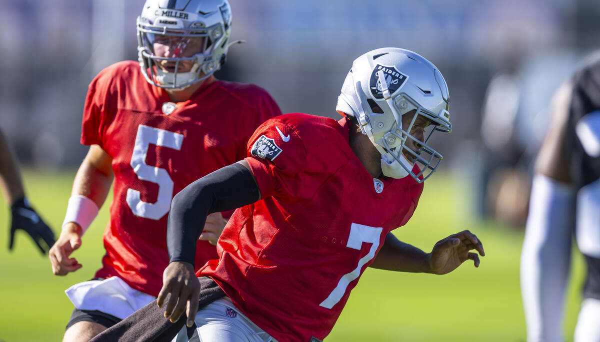Raiders quarterback Geno Smith (7) runs a drill with quarterback Cam Miller (5) behind during t ...