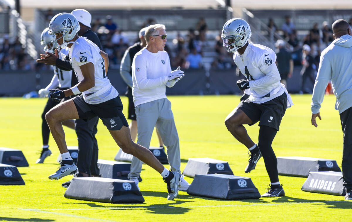 Raiders head coach Pete Carroll encourages wide receiver Shedrick Jackson (4) as he and others ...