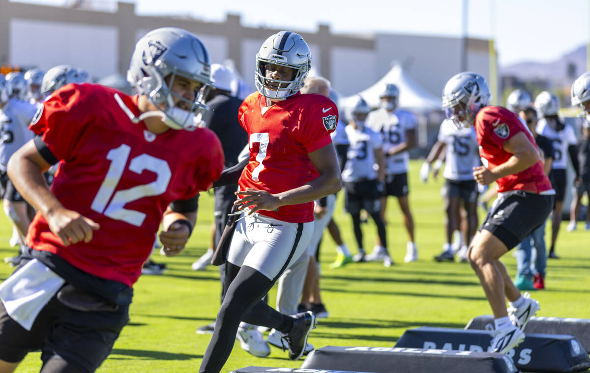 Raiders quarterback Geno Smith (7) runs a drill between quarterbacks Aidan O'Connell (12) and C ...
