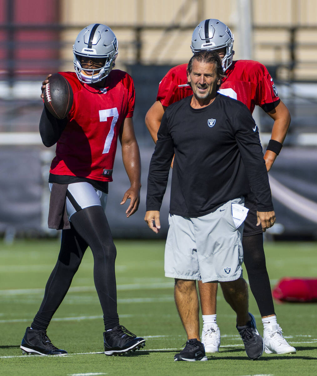 Raiders quarterback Geno Smith (7) grabs a ball for passing drills beside quarterbacks coach Gr ...