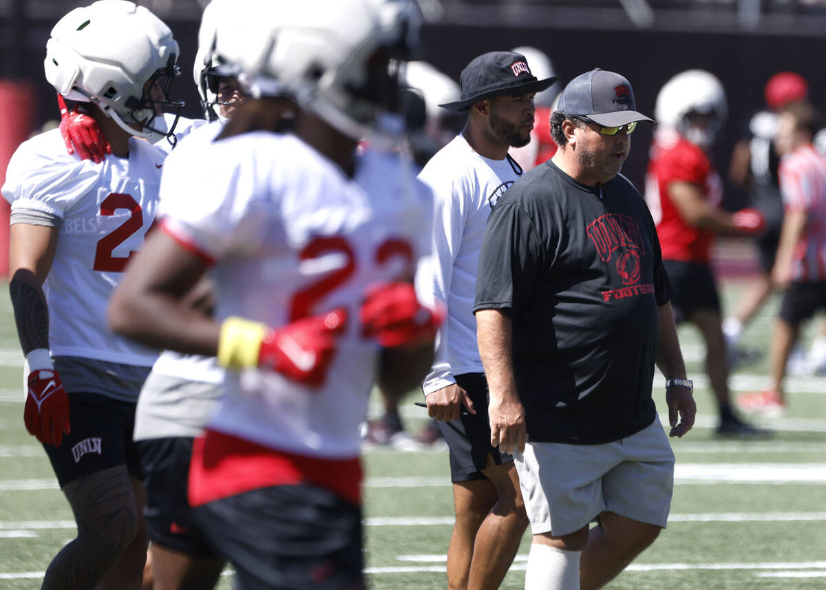 UNLV football interim defensive coordinator Paul Guenther, right, takes the field with his play ...