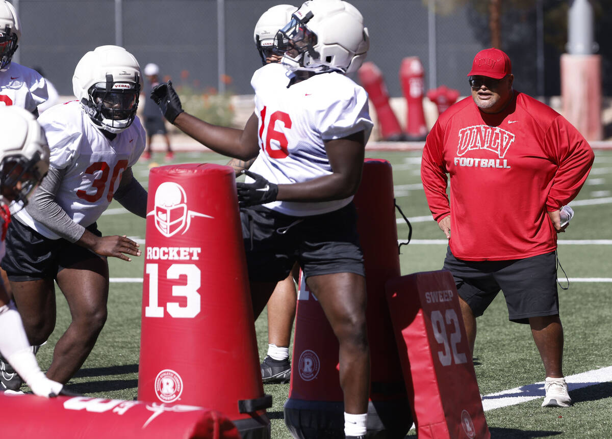 UNLV football defensive line coach Ricky Logo, right, watches as players work on drills during ...