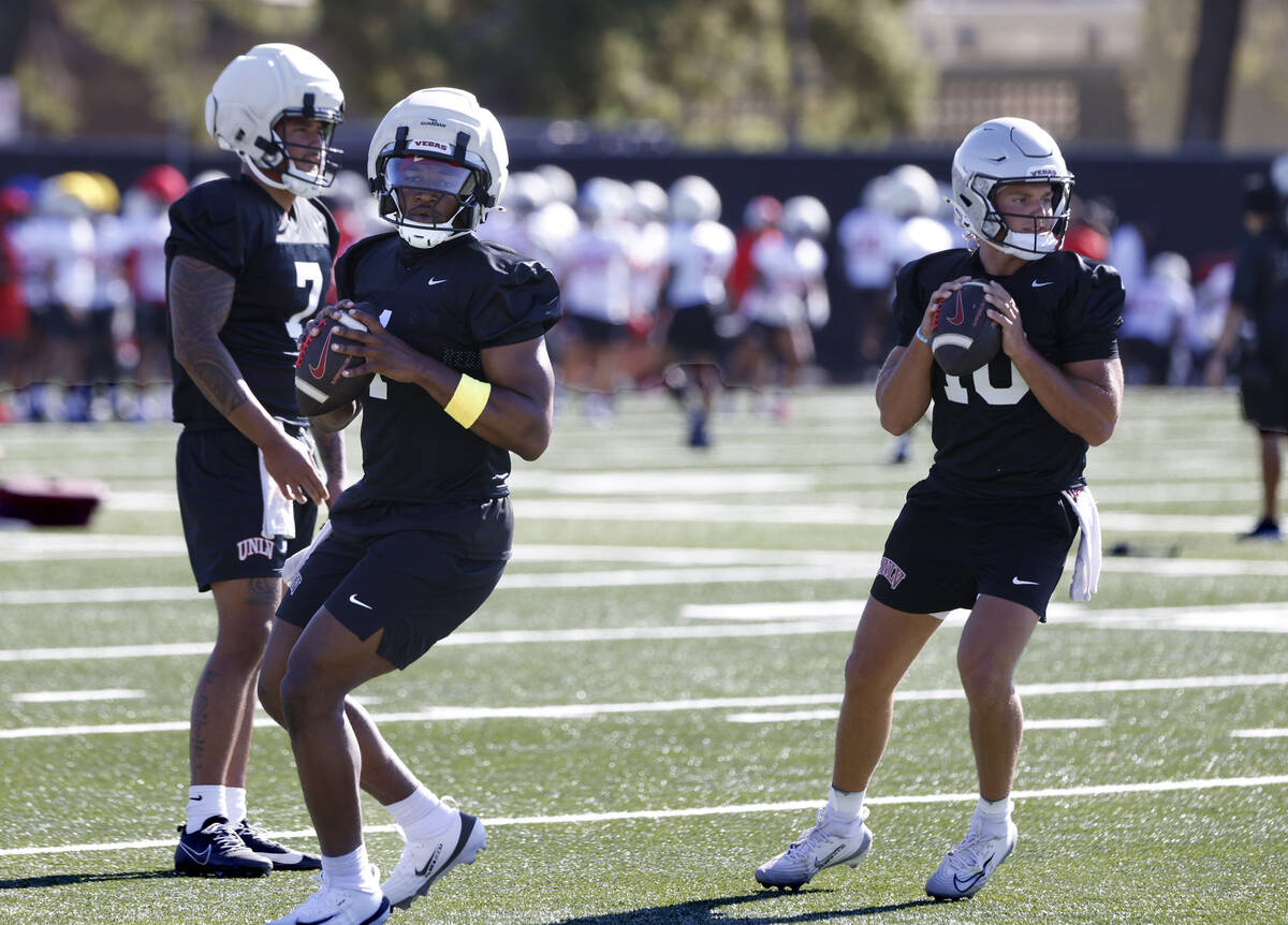 UNLV quarterbacks Alex Orji, center, and Anthony Colandrea (10) prepare to throw the ball as qu ...