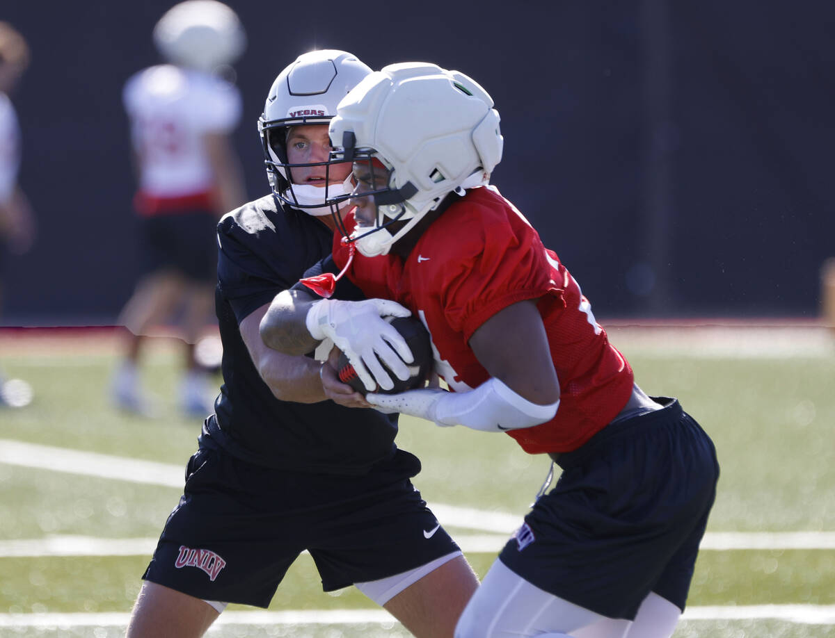 UNLV quarterback Anthony Colandrea, left, hands the ball to running back Darrien Jones during t ...