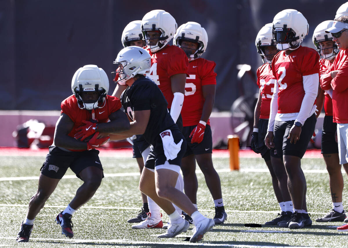 UNLV quarterback Anthony Colandrea, right, hands the ball to running back Jai'Den Thomas (9) du ...