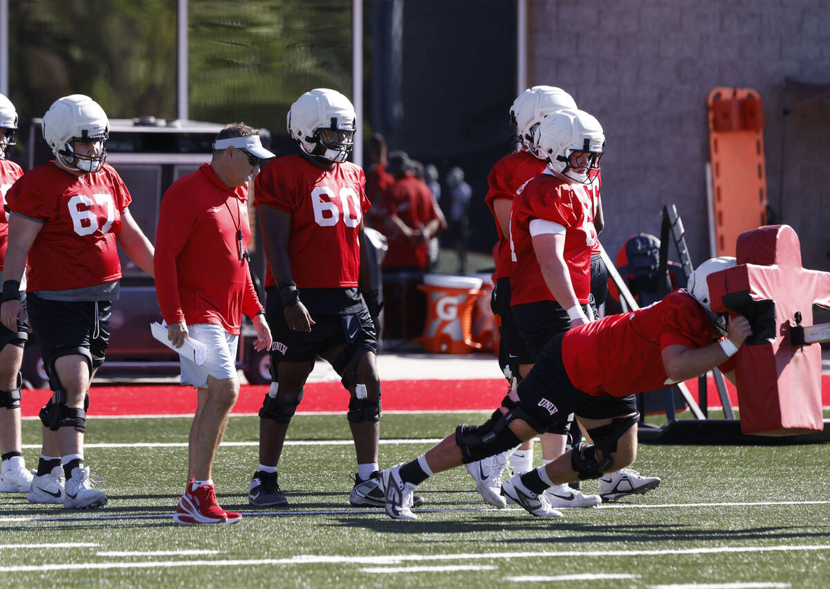UNLV head coach Dan Mullen, second left, watches as players work on drills during the first da ...