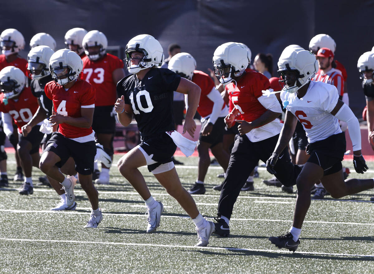 UNLV players, including quarterback Anthony Colandrea, center, warm up during the first day of ...