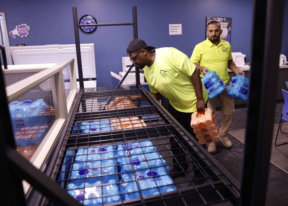 HELP of Southern Nevada outreach workers, Armond Clark, left, and Abdul Hamdard stock cases of ...