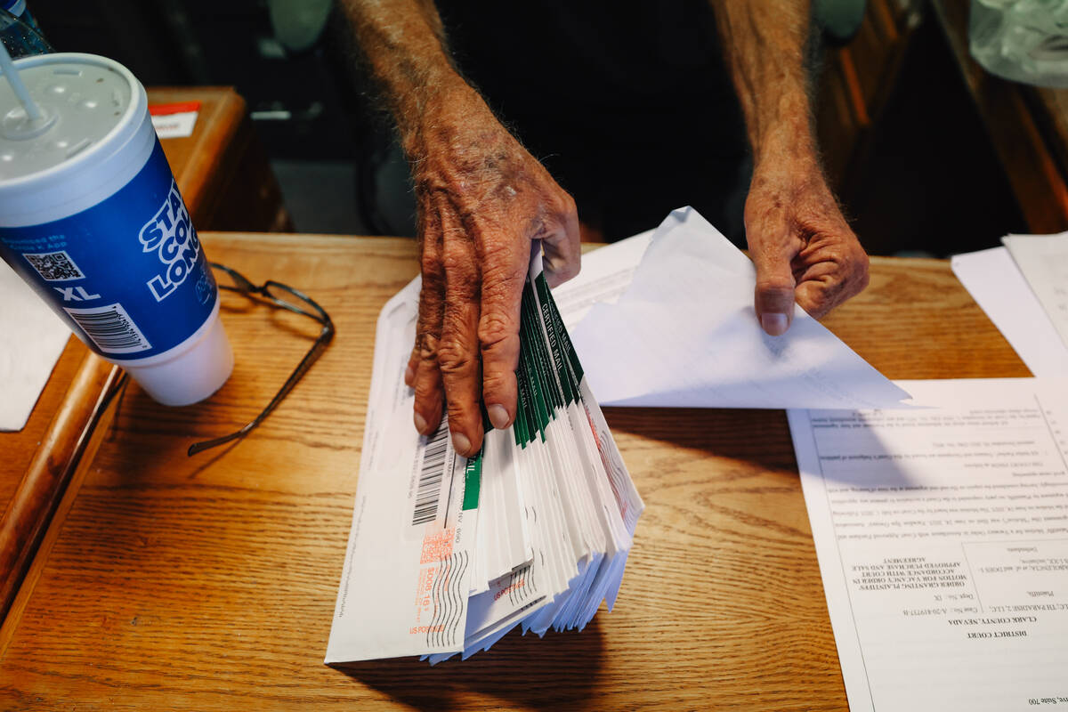 Dennis Snapp, the president of the Paradise Spa HOA, shows mail for tenants who must move out n ...