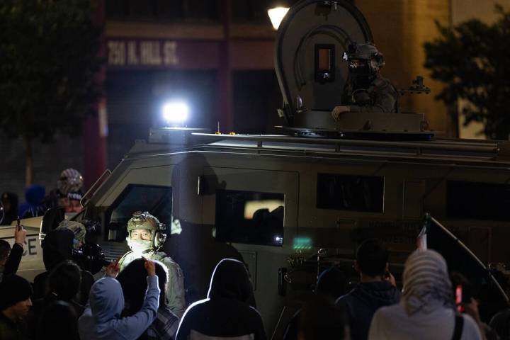 ICE officers try to leave the scene after performing a raid but protesters block their way in C ...