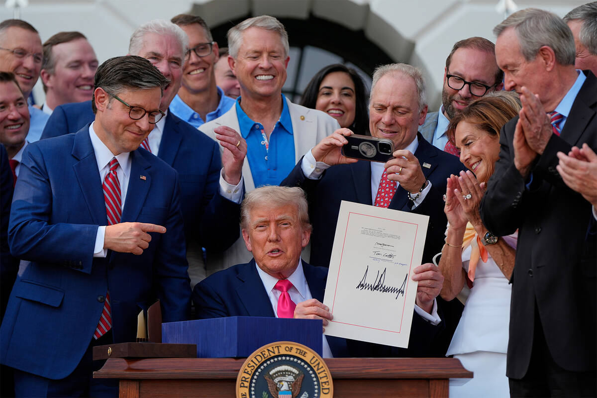 President Donald Trump holds his signed signature bill of tax breaks and spending cuts at the W ...