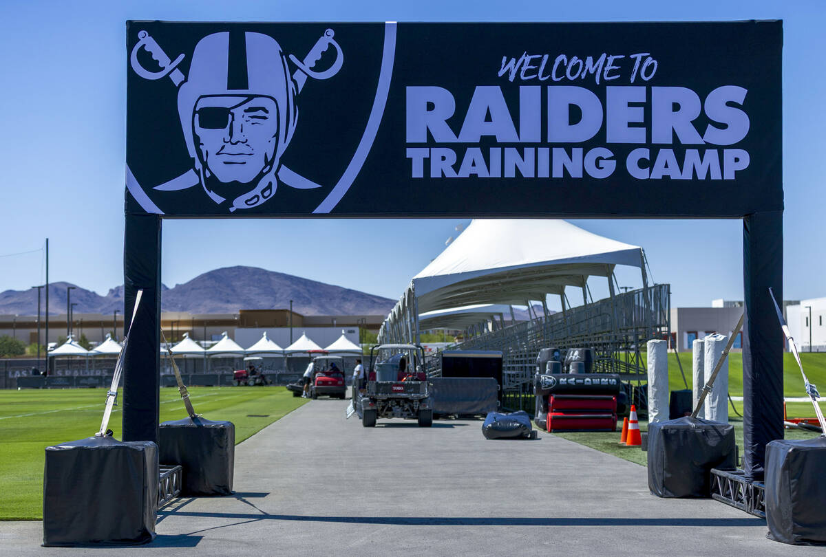 The team welcomes fans at a field entrance during the first day of training camp on Wednesday, ...