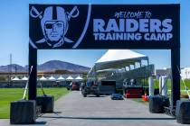 The team welcomes fans at a field entrance during the first day of training camp on Wednesday, ...