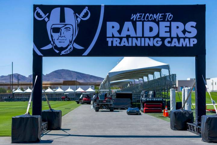 The team welcomes fans at a field entrance during the first day of training camp on Wednesday, ...