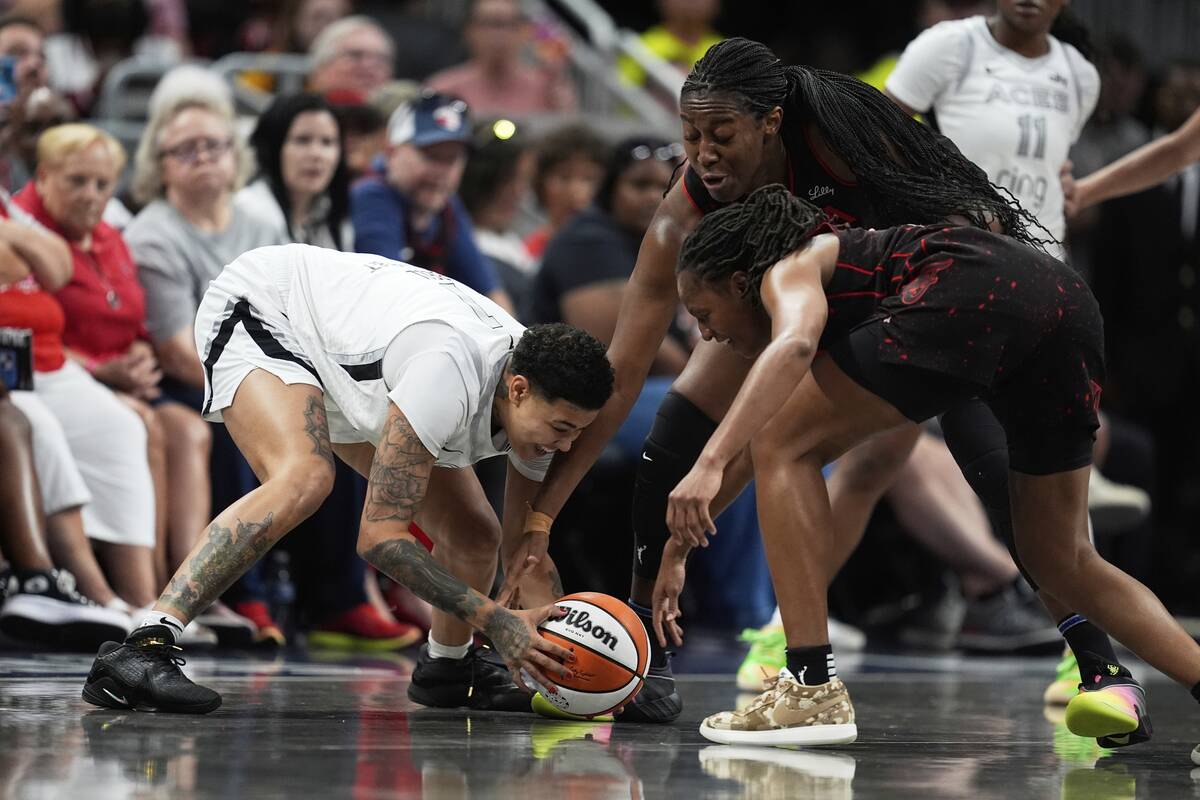 Las Vegas Aces' Kierstan Bell, left, is defended by Indiana Fever's Kelsey Mitchell (0) and Ali ...