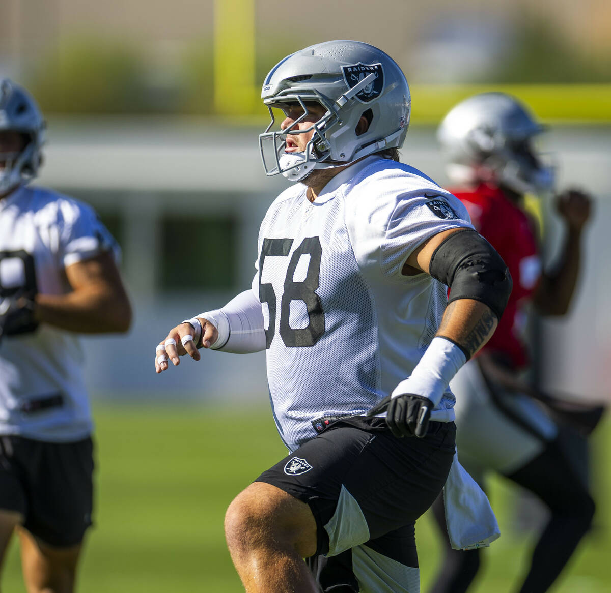 Raiders guard Jackson Powers-Johnson (58) warms up with teammates during the first day of train ...