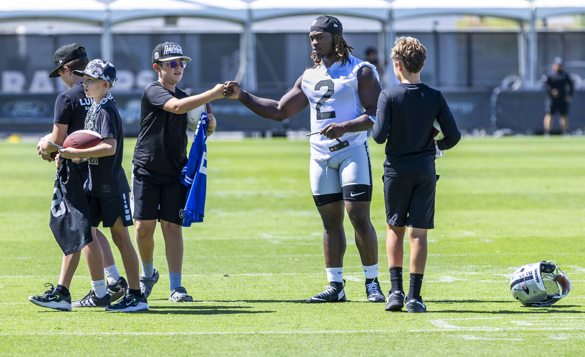 Raiders running back Ashton Jeanty (2) signs autographs for young fans during an interview on t ...