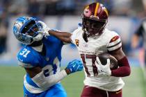 Washington Commanders wide receiver Terry McLaurin (17) stiff arms Detroit Lions safety Kerby J ...