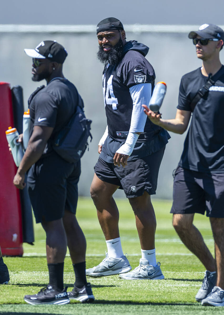 Raiders Christian Wilkins (94), center, looks on as teammates run a drill as he continues to re ...