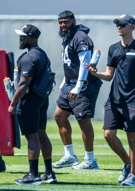 Raiders Christian Wilkins (94), center, looks on as teammates run a drill as he continues to re ...
