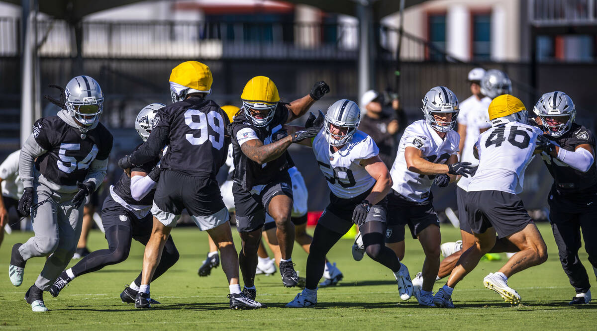 Raiders players battle at the line on a punt drill during the third day of training camp on Fri ...