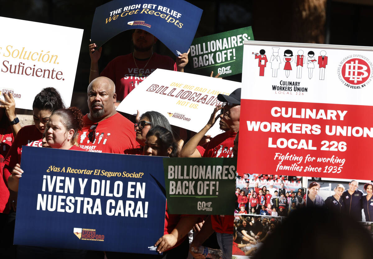 Members of Culinary Local 226 hold signs during a press conference where Rep. Steven Horsford, ...