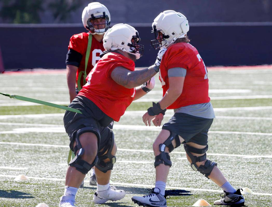 UNLV's offensive lines Alani Makihele, left, and Austin Boyd work on drills during the first da ...
